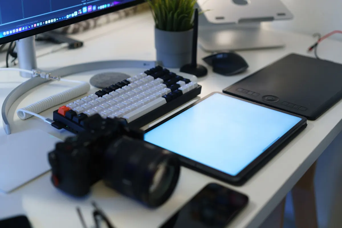 A freelance designer working on a laptop at a tidy desk in a bright home office.