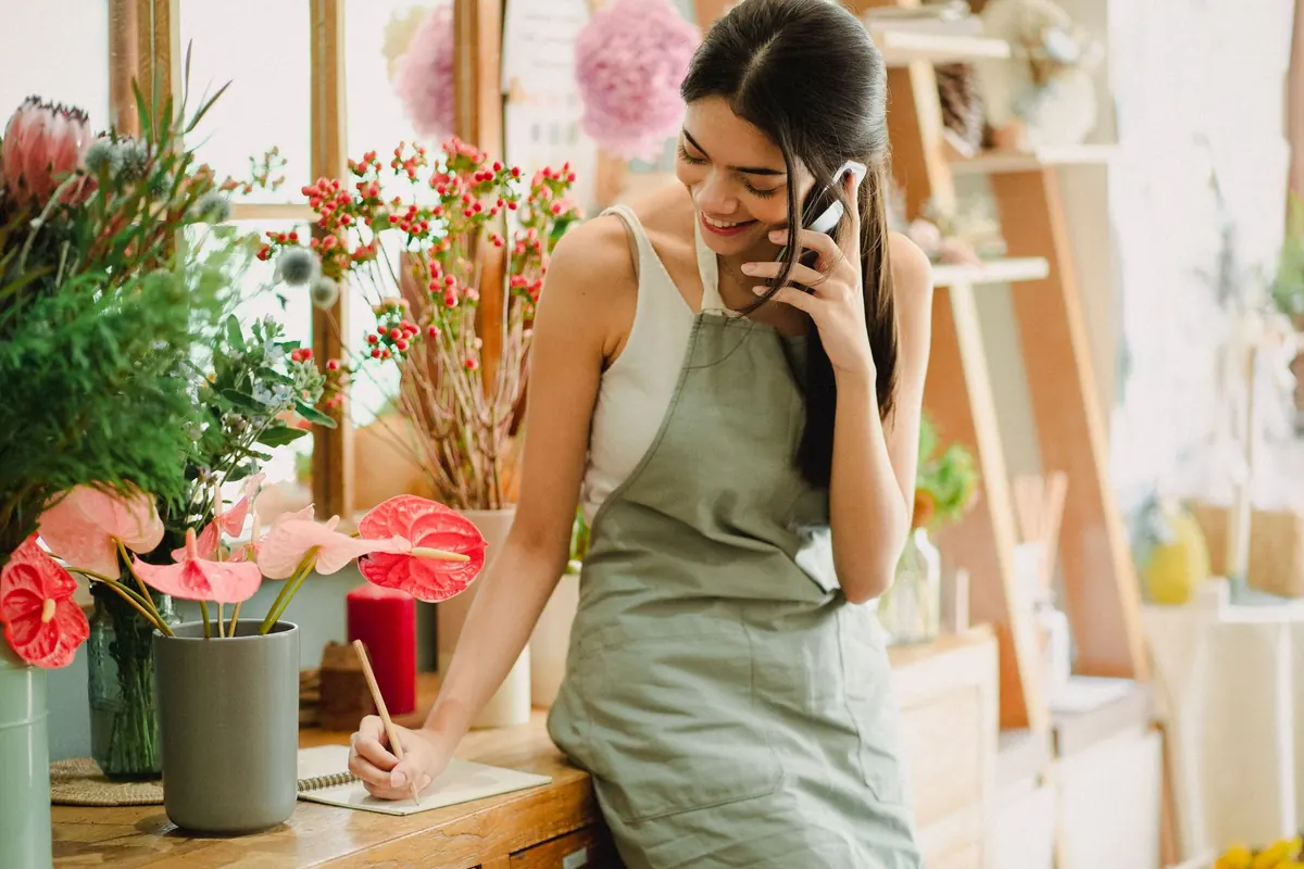 A small business owner sitting with a phone, typing replies to customer messages.