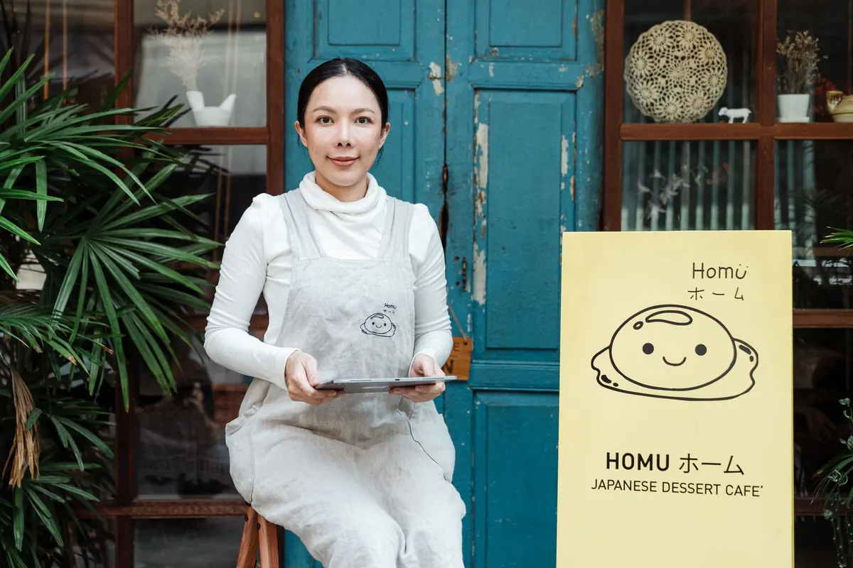 A cafe owner checking a tablet at the counter between customers.