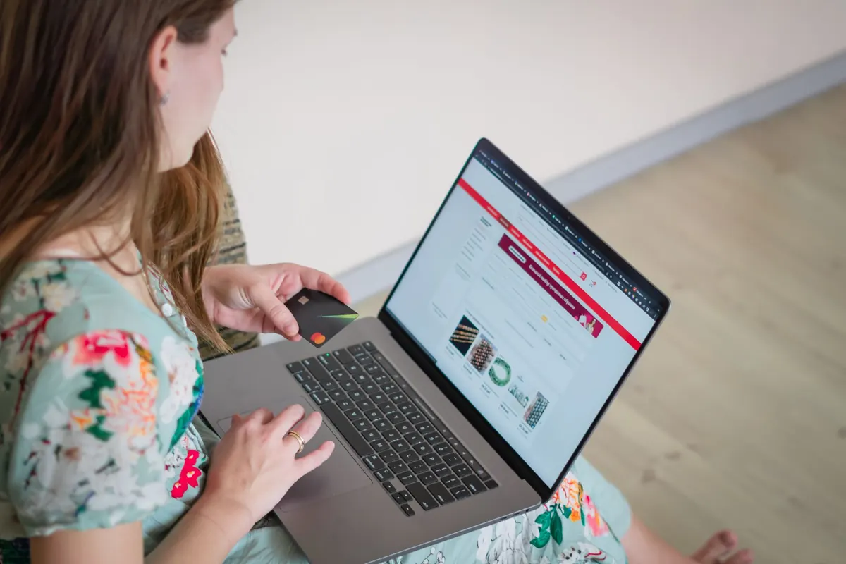 A small shop owner editing her website on a laptop at the counter of her store.