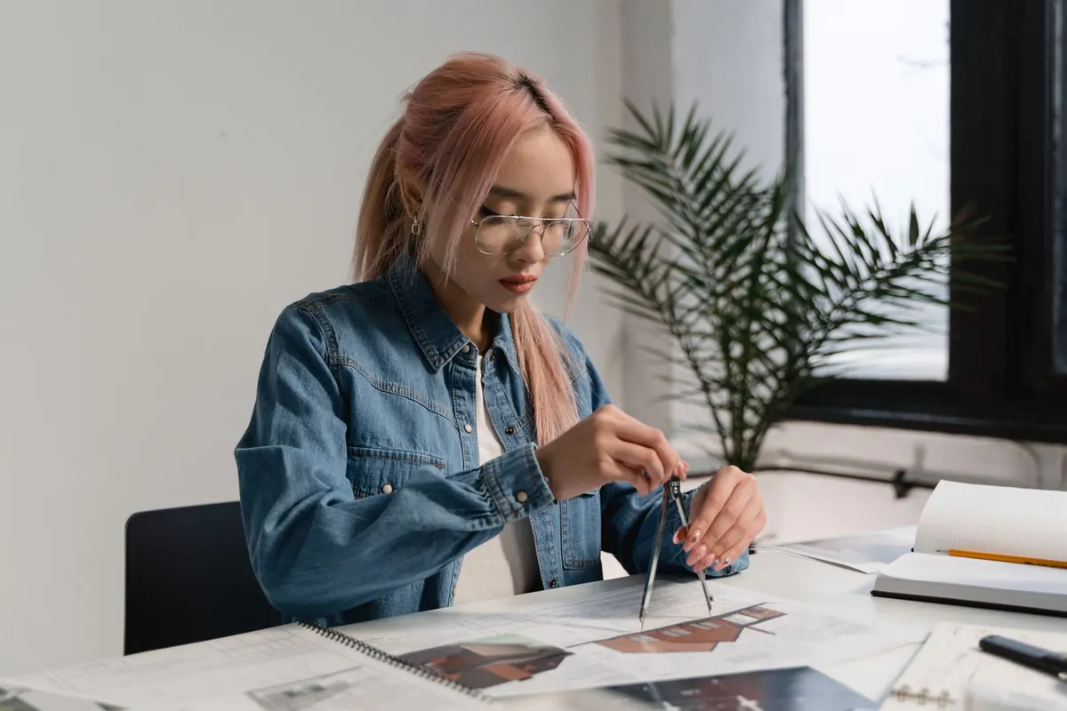 A web designer edits a website layout on a large monitor at a tidy desk.